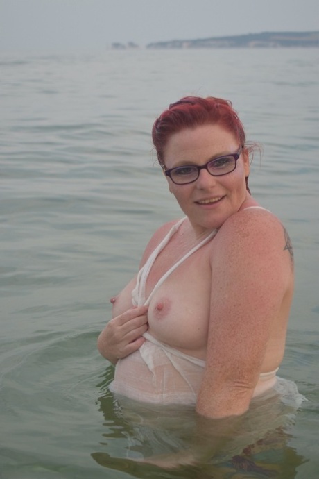 Tattooed redhead poses nude on a beach before masturbating on a toilet seat