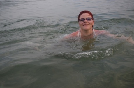 Tattooed redhead poses nude on a beach before masturbating on a toilet seat
