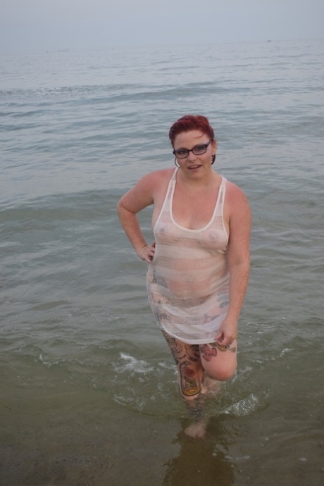 Tattooed redhead poses nude on a beach before masturbating on a toilet seat