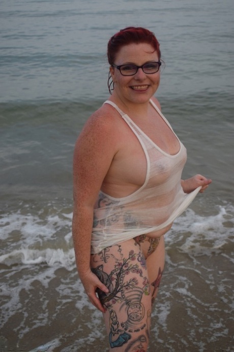 Tattooed redhead poses nude on a beach before masturbating on a toilet seat