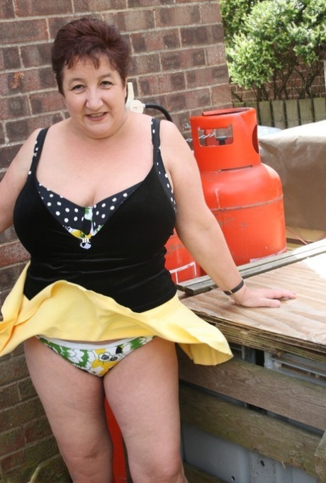 Fat older woman Kinky Carol flashes her bra and upskirt underwear on a patio