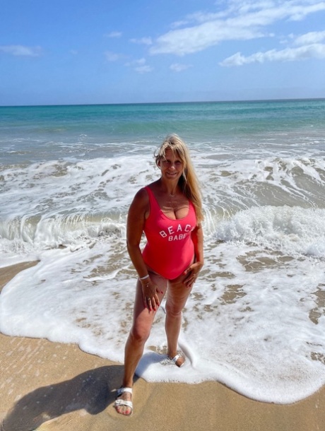 Middle-aged blonde Sweet Susi gets totally naked on a sandy beach
