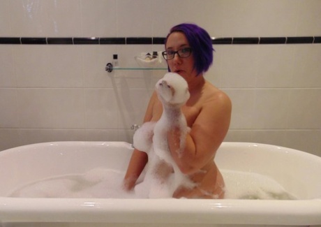 Mature plumper Sara Banks sports dyed hair while taking a bubble bath