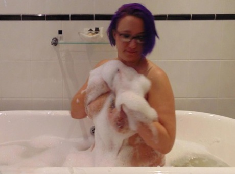 Mature plumper Sara Banks sports dyed hair while taking a bubble bath