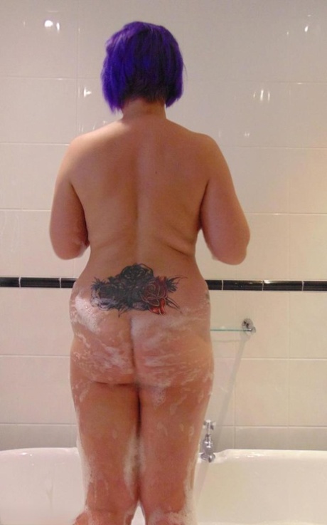 Mature plumper Sara Banks sports dyed hair while taking a bubble bath
