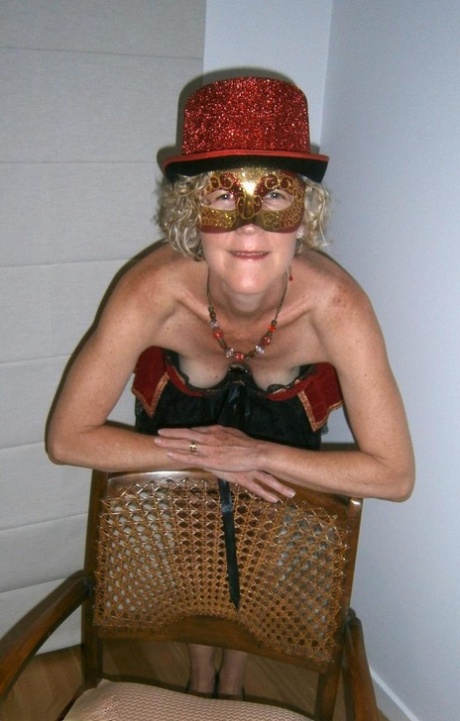 Old blonde woman Jacqueline gets naked in a funky hat and masquerade mask