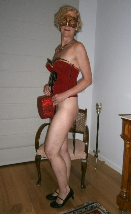 Old blonde woman Jacqueline gets naked in a funky hat and masquerade mask