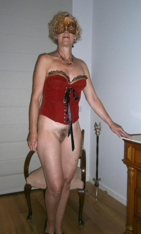 Old blonde woman Jacqueline gets naked in a funky hat and masquerade mask