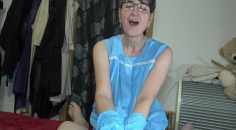 Mature woman Hot MILF oils up a cock while wearing blue latex gloves