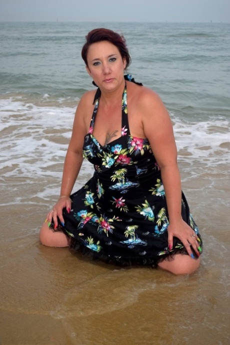 Older lady Sara Banks shows her tits and pussy on a beach in the surf