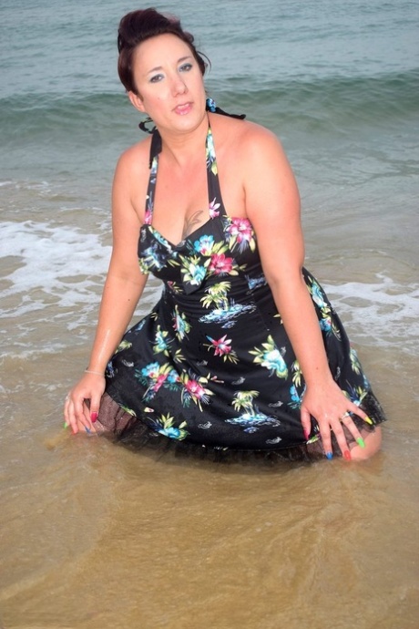 Older lady Sara Banks shows her tits and pussy on a beach in the surf