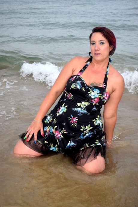 Older lady Sara Banks shows her tits and pussy on a beach in the surf