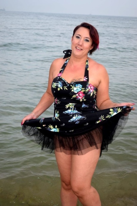 Older lady Sara Banks shows her tits and pussy on a beach in the surf