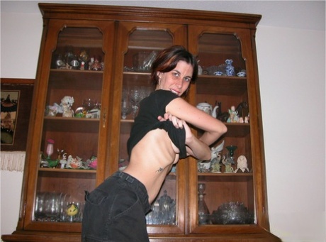Skinny older lady with an ugly face parts her pussy lips while getting naked
