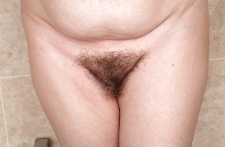 Older lady Christina X baring flabby stomach and hairy pussy