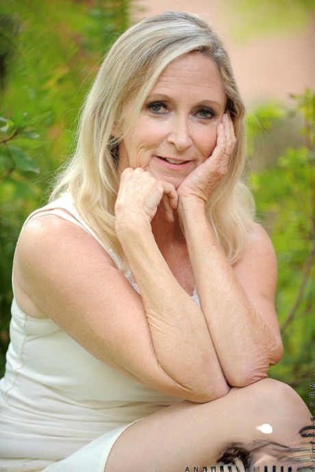 Mature lady Ann Brady heads to the garden to strip to tan stockings