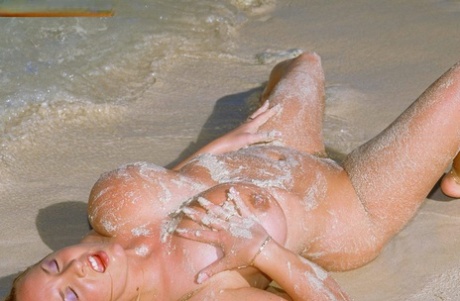 MILF Jessica Turner flaunts her big tits & fingers her horny muff on the beach