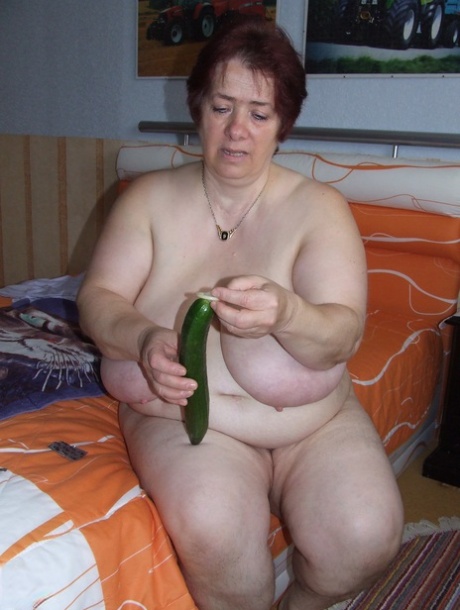 Fat mature Corinna puts a condom on a huge cucumber and masturbates