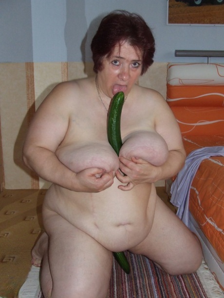 Fat mature Corinna puts a condom on a huge cucumber and masturbates