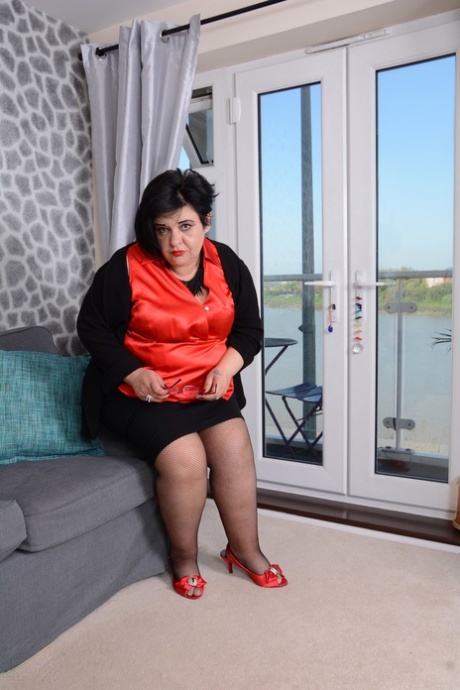 Chubby woman in stockings Anna masturbates with a dildo on the couch