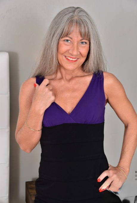 Mature lady with silver hair and a flat chest strips to masturbate on her bed