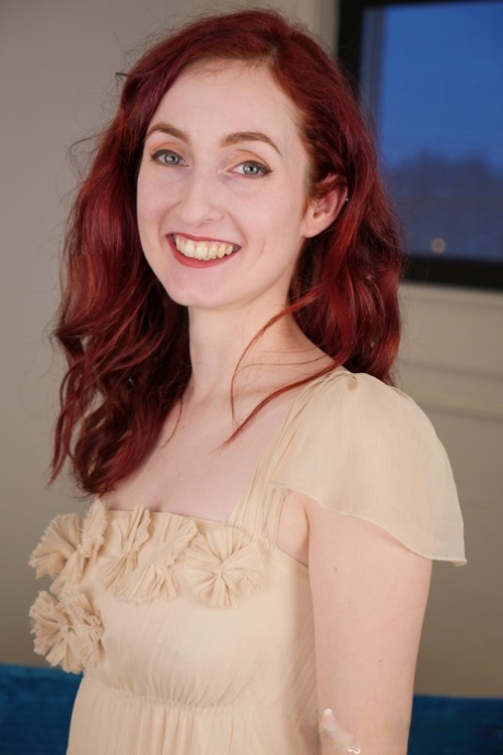 Slender redhead sweetie Penny Lay takes off her dress and fingers her pussy