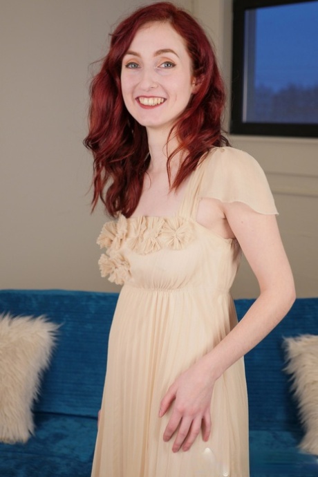 Slender redhead sweetie Penny Lay takes off her dress and fingers her pussy