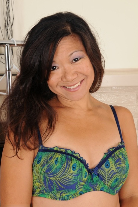 Asian brunette Samantha W shows her small tits and big ass while dressing