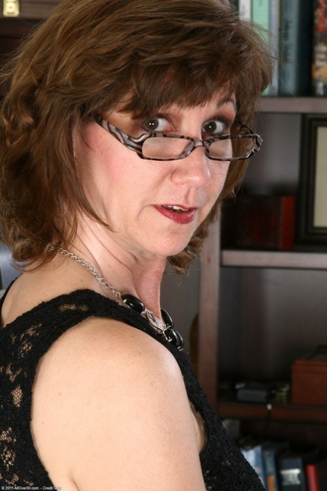 Mature woman Lynn bares her saggy breasts and plays with her shaved pussy