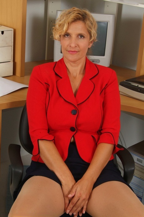 Mature secretary Tara unveils her saggy tits in a sexy office striptease
