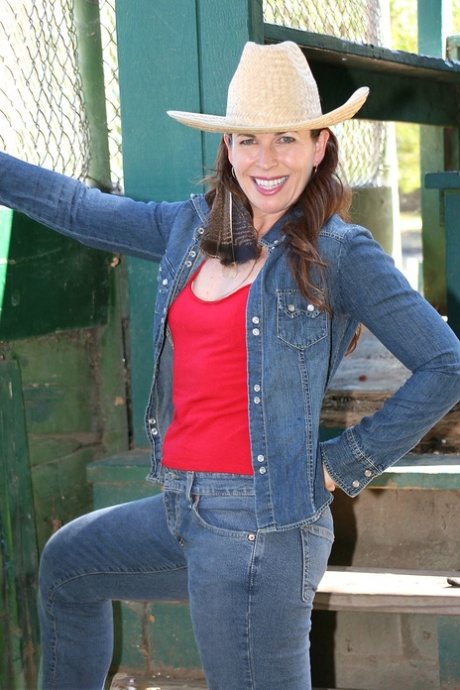 Mature cowgirl Andie shows her small tits & her hairy pussy outdoors