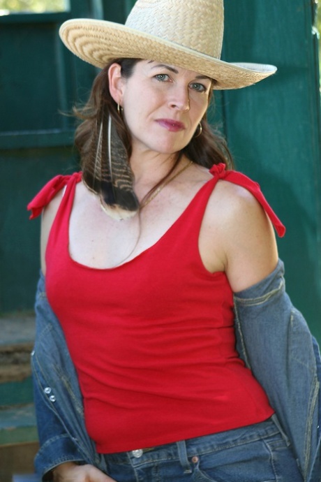 Mature cowgirl Andie shows her small tits & her hairy pussy outdoors