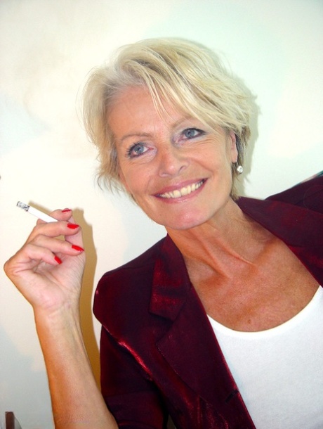 Mature lady Justine exposes her saggy tanned tits while smoking a cigarette