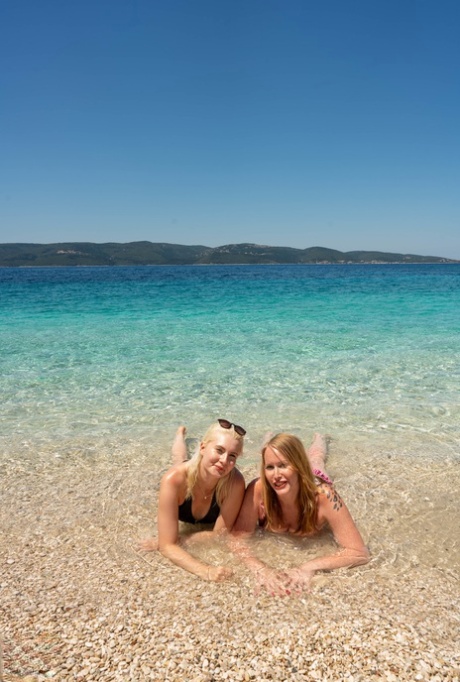 Moms with big booties Mackenzie Page and Miss Melissa pose nude on the beach