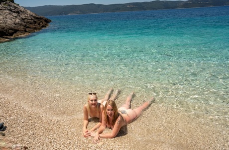 Moms with big booties Mackenzie Page and Miss Melissa pose nude on the beach