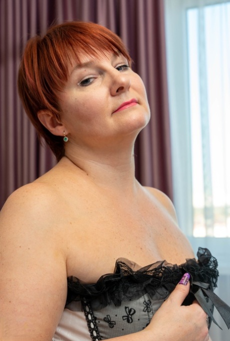 Short-haired mature woman Nadine grabs her big tits while toying her pussy