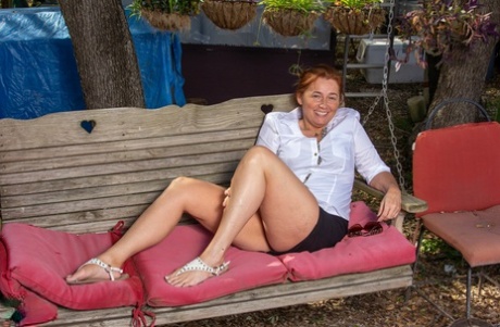 Chubby mature redhead Gypsy Leigh exposes her big tits & toys her cunt outside