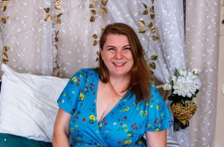 Fat amateur mom Darcy Rosa flashes her hot red undies on a bed in a solo