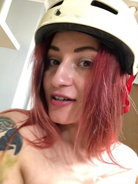 Pretty redhead teases with her lovely tits and inked body in the mirror