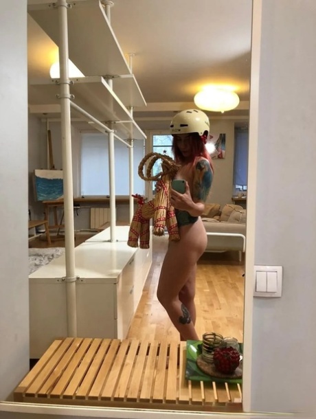 Pretty redhead teases with her lovely tits and inked body in the mirror