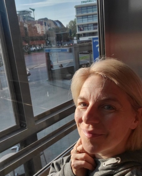Blue-eyed mature blonde flaunts her hot curvy body while posing in the window