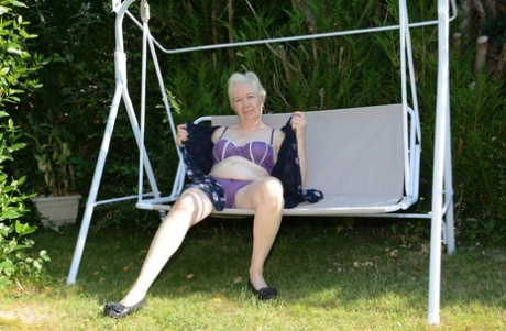Big boobed granny Caroline stripping on the swing and toying her fat pussy